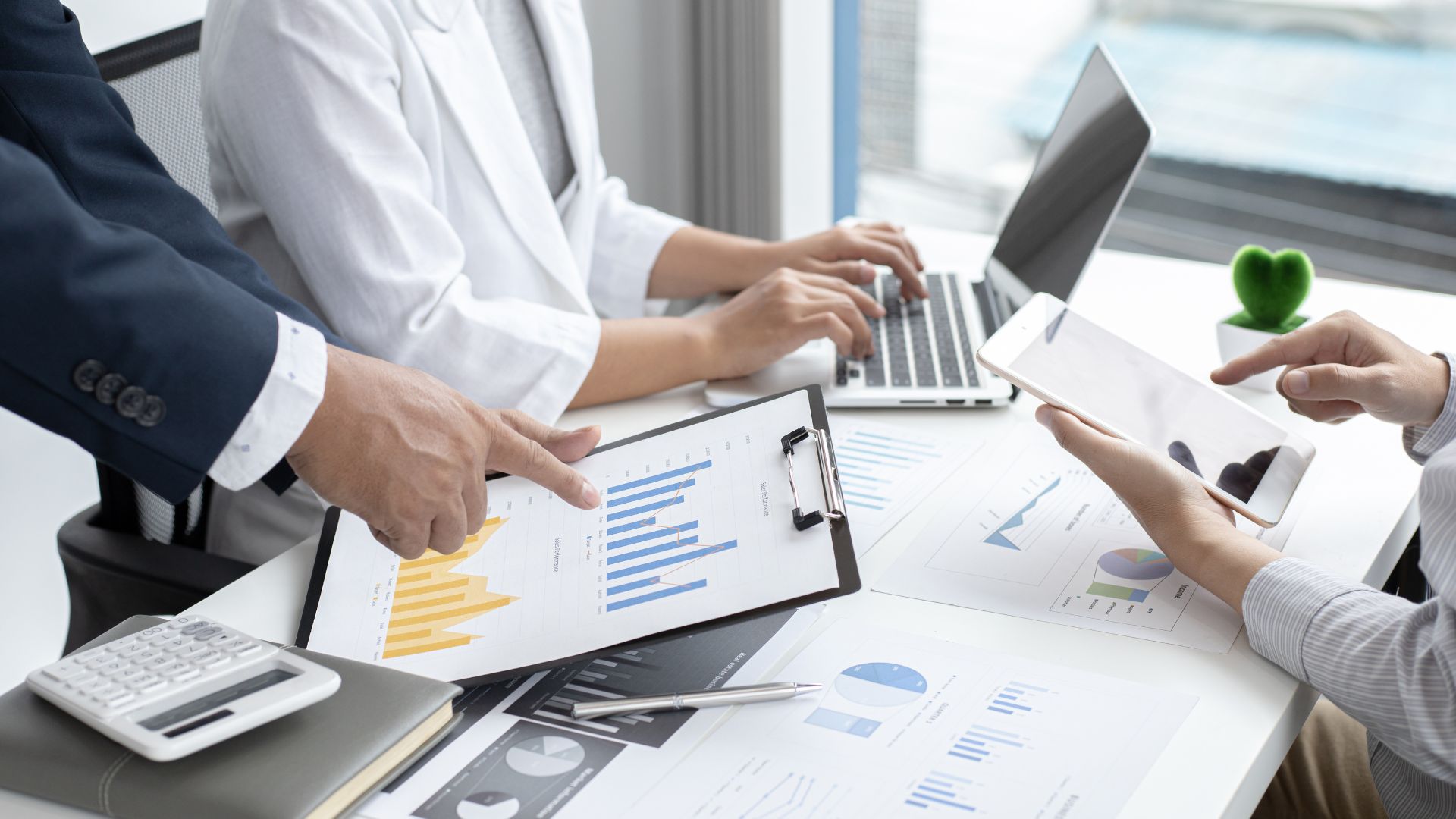 Business Team Analyzing Financial Data On Laptops