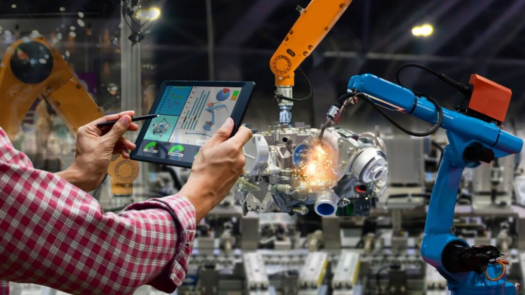 engineer monitoring robotic manufacturing system with tablet
