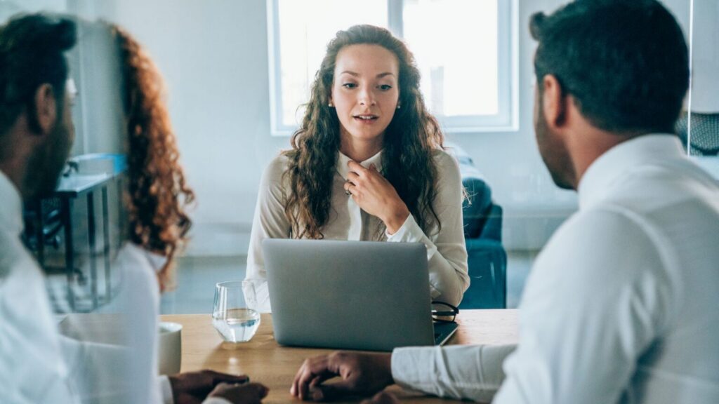 Team meeting at an office table with laptop