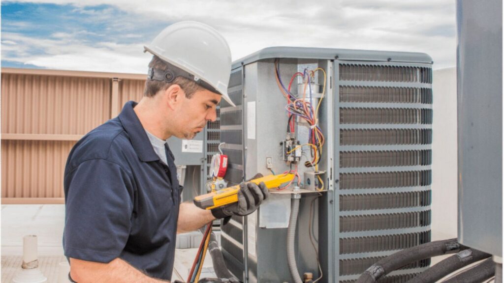 Technician repairing rooftop HVAC unit