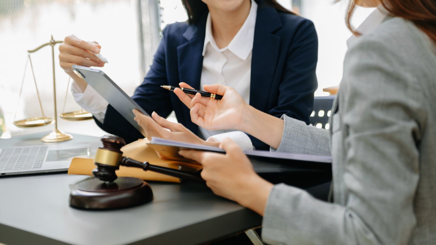Two IT Professionals Discussing With A Tablet And Legal Documents